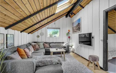 a living room with a couch and a table at Nice Home In Løkken With Kitchen in Løkken
