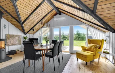 a dining room with a table and chairs at Nice Home In Løkken With Kitchen in Løkken