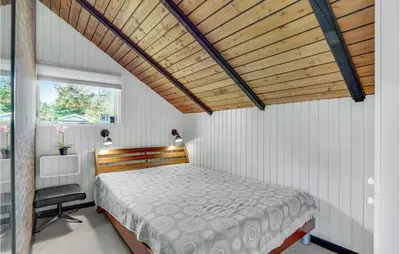 a bedroom with a bed with a wooden ceiling at Nice Home In Løkken With Kitchen in Løkken