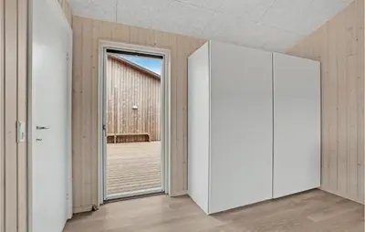 an open door in a room with a wooden floor at Nice Home In Løkken With Sauna in Løkken