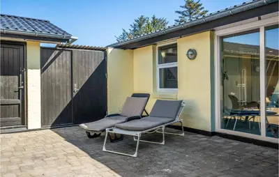 a pair of chairs sitting on a patio at Gorgeous Home In Blokhus With Sauna in Blokhus