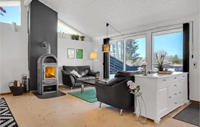 a living room with a couch and a fireplace at Gorgeous Home In Blokhus With Sauna in Blokhus