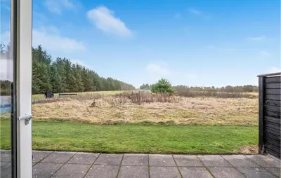 a view of a field through a sliding glass door at 2 Bedroom Beautiful Home In Pandrup in Pandrup