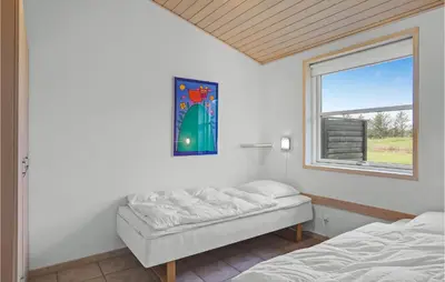 a bedroom with two beds and a window at 2 Bedroom Beautiful Home In Pandrup in Pandrup