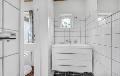 a white bathroom with a sink and a toilet at Gorgeous Apartment In Blokhus With Wifi in Blokhus