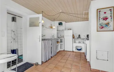 a kitchen with white appliances and a tile floor at Gorgeous Apartment In Blokhus With Wifi in Blokhus