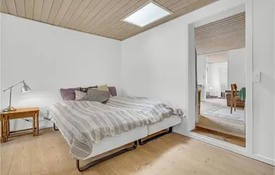 a white bedroom with a bed and a window at Gorgeous Apartment In Blokhus With Wifi in Blokhus