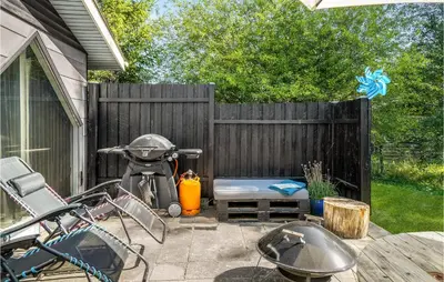 a patio with a bike parked next to a fence at 3 Bedroom Pet Friendly Home In Blokhus in Blokhus