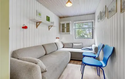 a living room with a couch and two blue chairs at 3 Bedroom Pet Friendly Home In Blokhus in Blokhus