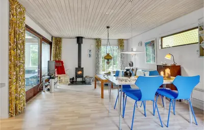 a dining room with a table and blue chairs at 3 Bedroom Pet Friendly Home In Blokhus in Blokhus