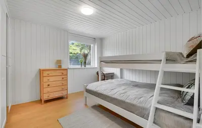 a bedroom with a bunk bed and a window at 4 Bedroom Amazing Home In Blokhus in Blokhus