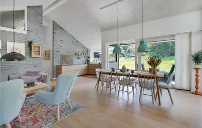 a dining room and living room with a table and chairs at 4 Bedroom Amazing Home In Blokhus in Blokhus