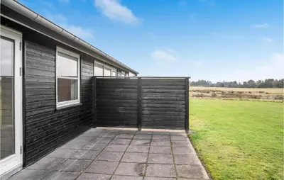 a wooden garage door on the side of a house at 2 Bedroom Lovely Home In Pandrup in Pandrup