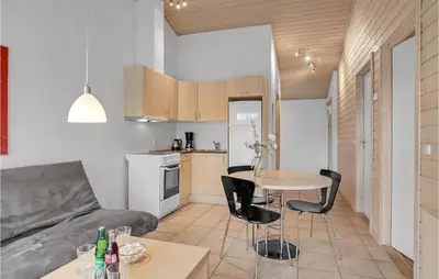a kitchen and living room with a table and chairs at Cozy Home In Pandrup With Wifi in Pandrup