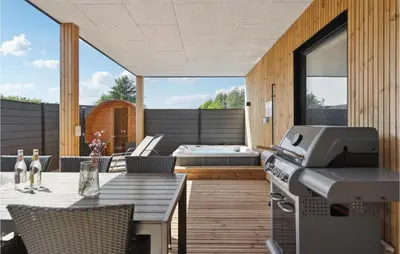 a backyard patio with a table and a printer at Stunning Home In Blokhus With Kitchen in Blokhus