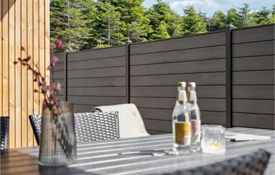 two bottles of beer sitting on a table on a patio at Stunning Home In Blokhus With Kitchen in Blokhus