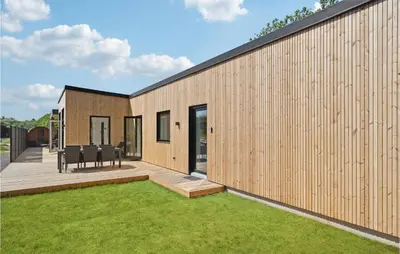 a modular home with a deck and grass at Stunning Home In Blokhus With Kitchen in Blokhus