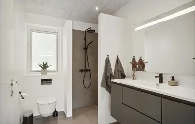 a bathroom with a sink and a toilet and a window at Stunning Home In Blokhus With Kitchen in Blokhus