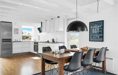a kitchen and dining room with a wooden table and chairs at 3 Bedroom Gorgeous Home In Blokhus in Blokhus