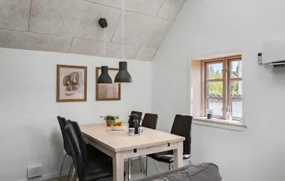 a dining room with a wooden table and black chairs at 3 Bedroom Stunning Home In Pandrup in Pandrup