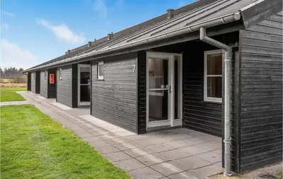 a black building with a large door on the side at 2 Bedroom Nice Home In Pandrup in Pandrup