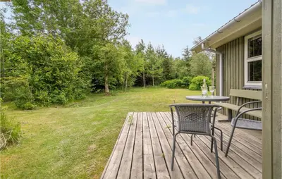 a patio with a table and chairs on a deck at 3 Bedroom Gorgeous Home In Pandrup in Pandrup