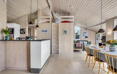 a kitchen and dining room with a table and chairs at Nice Home In Blokhus With Kitchen in Blokhus