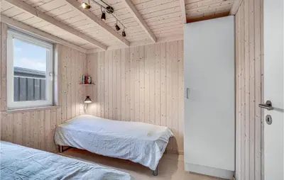 a bedroom with two beds and a window at Nice Home In Blokhus With Kitchen in Blokhus