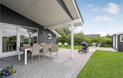 a patio with a table and chairs on a patio at Amazing Home In Brovst With Kitchen in Brovst