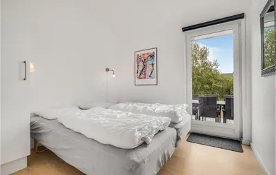 a white bedroom with a large bed and a window at Amazing Home In Brovst With Kitchen in Brovst