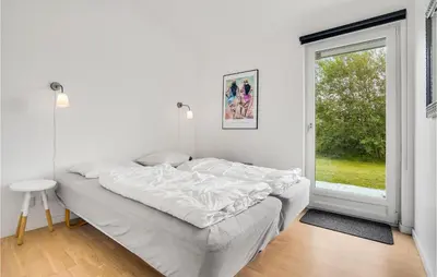 a white bedroom with a bed and a window at Amazing Home In Brovst With Kitchen in Brovst
