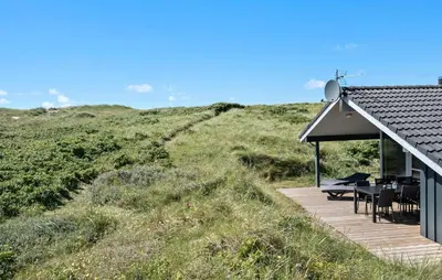 a house on the side of a hill with a deck at 3 Bedroom Awesome Home In Harboøre in Harboør
