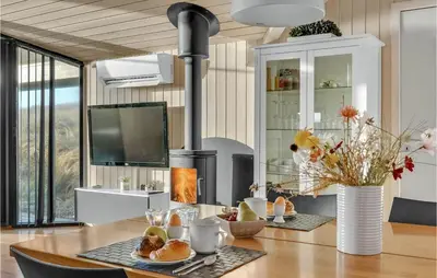 a kitchen with a table with a wood stove at 3 Bedroom Awesome Home In Harboøre in Harboør