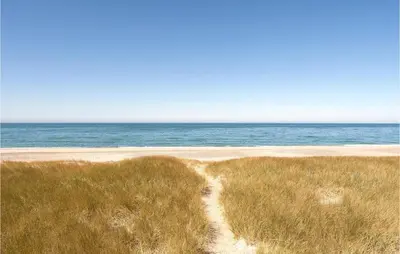 a path through a field of grass next to the ocean at 3 Bedroom Awesome Home In Harboøre in Harboør