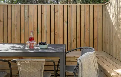 a table with chairs and a bottle of wine on a fence at Beautiful Home In Thisted With Kitchen in Thisted