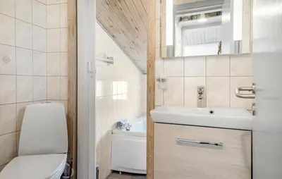a small bathroom with a toilet and a sink at Beautiful Home In Thisted With Kitchen in Thisted