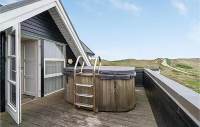 a hot tub on the deck of a house at Lovely Home In Harboøre With Sauna in Harboør