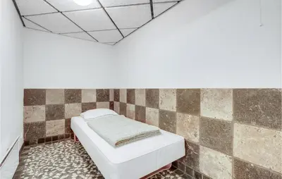 a bed in a room with a tiled wall at Lovely Home In Harboøre With Sauna in Harboør