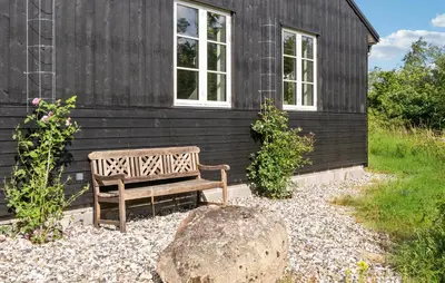 a wooden bench sitting in front of a building at 3 Bedroom Cozy Home In Vemb in Vemb