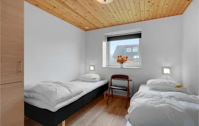 two beds in a room with a window and a chair at Awesome Home In Vestervig With Wifi in Vestervig