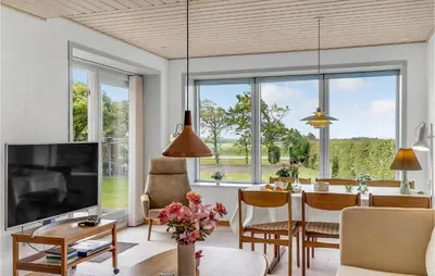 a living room with a table and a large window at Awesome Home In Vestervig With Wifi in Vestervig