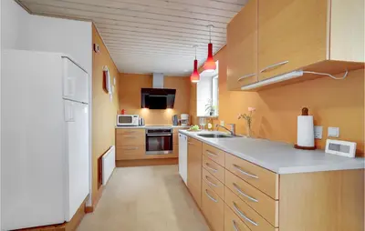 a kitchen with wooden cabinets and a white refrigerator at Awesome Home In Vestervig With Wifi in Vestervig
