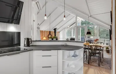 a kitchen with white cabinets and a table with chairs at Beautiful Home In Thisted With Kitchen in Thisted