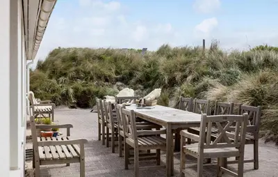 a wooden table and chairs on the beach at Gorgeous Home In Lemvig With Sauna in Lemvig