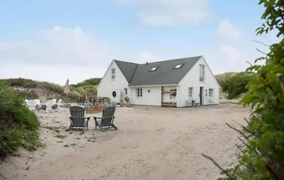 a white house with chairs on the beach at Gorgeous Home In Lemvig With Sauna in Lemvig