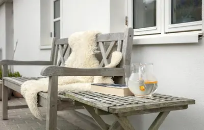a teddy bear sitting on a wooden chair with a book and a glass at Gorgeous Home In Lemvig With Sauna in Lemvig
