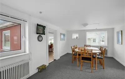 a dining room with a table and chairs and a clock at Lovely Home In Thisted With Kitchen in Thisted