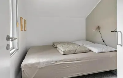 a bed in a white room with two pillows at 3 Bedroom Awesome Home In Thyholm in Thyholm