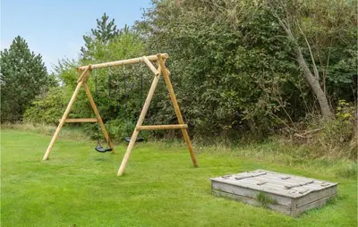 a wooden swing set in a field of grass at 3 Bedroom Amazing Home In Hurup Thy in Sindrup