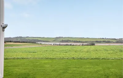 a train is traveling through a green field at Gorgeous Apartment In Lemvig in Lemvig